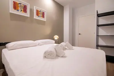 a bedroom with a white bed with towels on it at VLC HOST- Eixarchs in Valencia