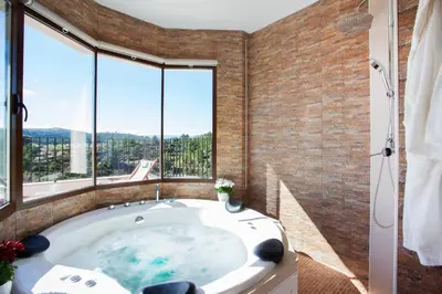 a bathroom with a large tub with large windows at Casa rural Torre Buena Vista a 40 minutos de Valencia con gran jacuzzi y vistas maravillosass in Benafer