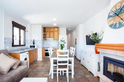 a kitchen and living room with a couch and a table at Casa rural Torre Buena Vista a 40 minutos de Valencia con gran jacuzzi y vistas maravillosass in Benafer