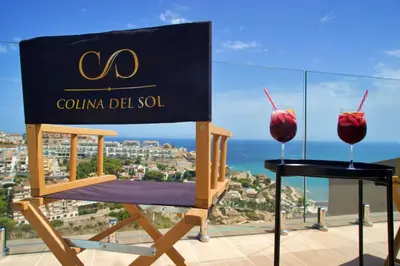 a sign sitting on a chair with two glasses of cherries at Colina del Sol Cullera - Villa Sol in Cullera