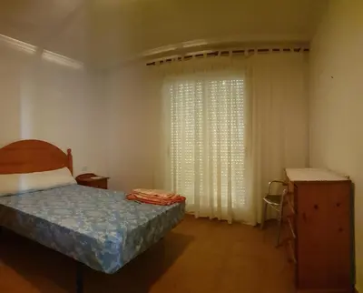 a bedroom with a bed and a window with curtains at Vacansis Adosado Marenyet in Cullera
