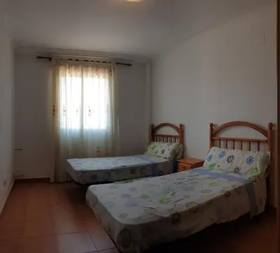 two beds sitting in a room with a window at Vacansis Adosado Marenyet in Cullera