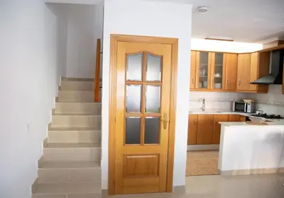 a kitchen and a door in a room with stairs at Summer Beach House in Puebla de Farnals