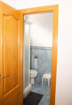 a bathroom with a toilet and a stool in it at Summer Beach House in Puebla de Farnals