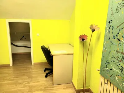 a yellow room with a desk and a chair and flowers at Palau de Vic in Valencia