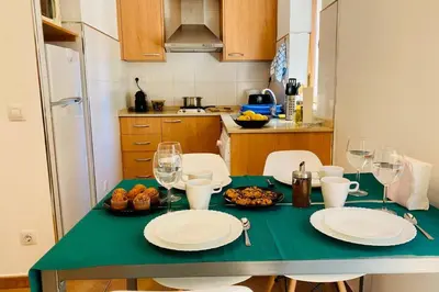 a kitchen with a table with plates and wine glasses at Acogedor apartamento centro histórico Valencia in Valencia