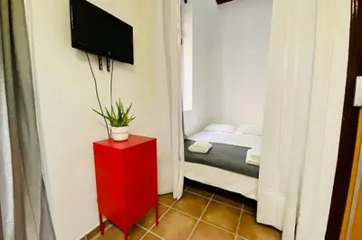 a room with a red cabinet with a tv on a wall at Acogedor loft en centro histórico in Valencia