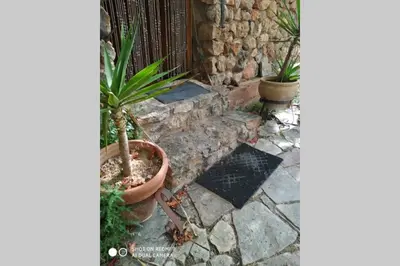 a patio with two potted plants and a fence at La Casa de Piedra, una ventana al paraíso in Matet