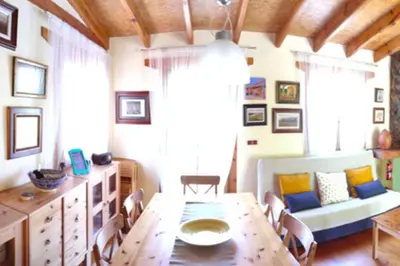 a dining room with a table and a couch at La Casa de Piedra, una ventana al paraíso in Matet