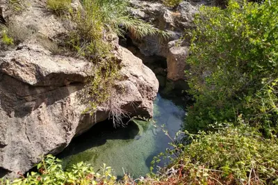 a pool of water between two large rocks at La Casa de Piedra, una ventana al paraíso in Matet