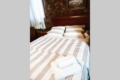 a bed with striped sheets and white towels on it at La Casa de Piedra, una ventana al paraíso in Matet