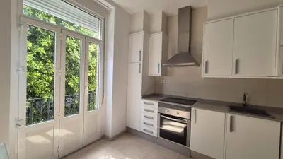 a kitchen with white cabinets and a large window at Luxury Apartments Puerto Valencia in Valencia