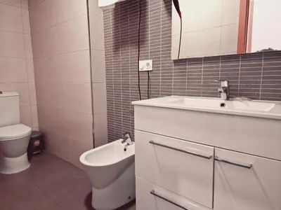 a white bathroom with a sink and a toilet at Luxury Apartments Puerto Valencia in Valencia