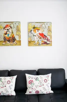 a couch with two paintings on the wall and two pillows at FLORIT FLATS - The Malvarrosa Beach Apartment & Free Parking in Valencia