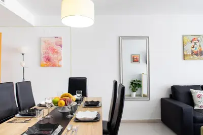a dining room with a table with chairs and a mirror at FLORIT FLATS - The Malvarrosa Beach Apartment & Free Parking in Valencia