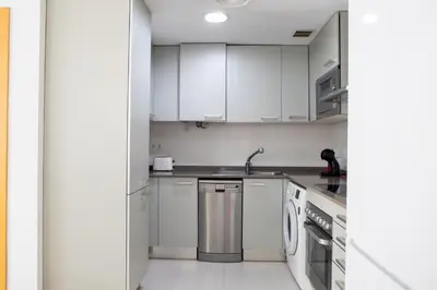 a kitchen with white cabinets and a sink at FLORIT FLATS - The Malvarrosa Beach Apartment & Free Parking in Valencia