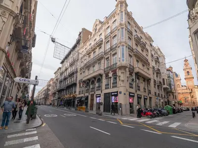 a large building on a city street with people walking at MD Vitoria City Center in Valencia