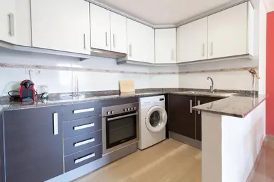 a kitchen with white cabinets and a washer and dryer at Global Vacacional, Apartamento a 200m de la playa de Puerto de Sagunto in Puerto de Sagunto