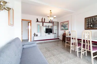 a living room with a couch and a table at Global Vacacional, Apartamento con terraza y piscina a un paso de la playa in Canet de Berenguer