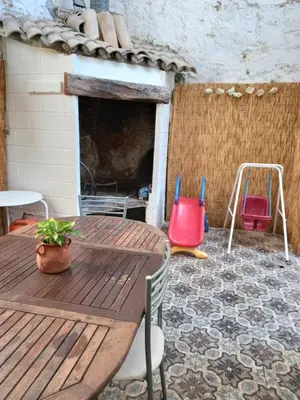 a patio with a wooden table and chairs and a playground at La Gata Mala in Navarrés