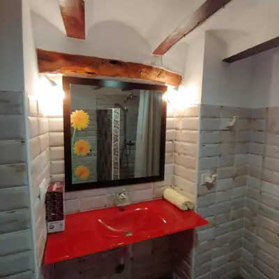 a bathroom with a red sink and a mirror at La Gata Mala in Navarrés