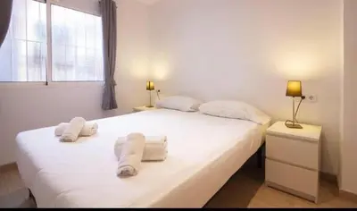 a bedroom with a large white bed with towels on it at Acogedor apartamento en Ruzafa-centro in Valencia