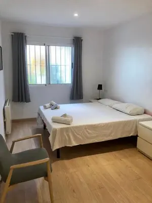 a bedroom with a large bed and a chair at Acogedor apartamento en Ruzafa-centro in Valencia