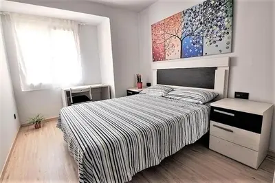 a living room with a couch and a table with yellow flowers at APTMUNDO ALTAMAR.- Precioso apartamento 1ª planta + terraza . Para 4 in Puerto de Sagunto