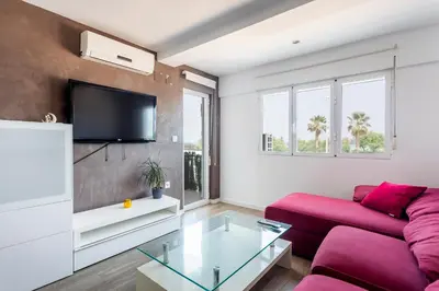 a living room with a red couch and a tv at Fantástico Apartamento en Primerísima Línea Playa in La Torre