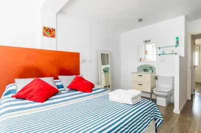 a bedroom with a bed with red and white pillows at Fantástico Apartamento en Primerísima Línea Playa in La Torre