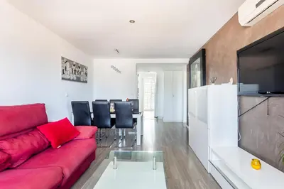 a living room with a red couch and a table at Fantástico Apartamento en Primerísima Línea Playa in La Torre