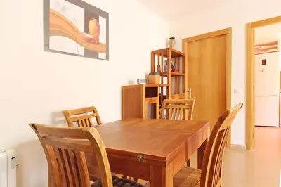 a dining room with a wooden table and chairs at Global Vacacional, Ático con 2 terrazas en la playa Puerto de Sagunto in Puerto de Sagunto
