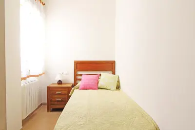 a bedroom with a bed with a wooden headboard and a dresser at Global Vacacional, Ático con 2 terrazas en la playa Puerto de Sagunto in Puerto de Sagunto