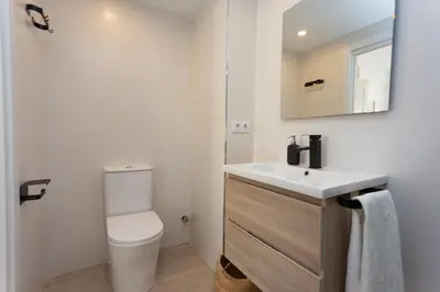 a bathroom with a white toilet and a sink at Apartamento Los Olivos II - Cullera in Cullera