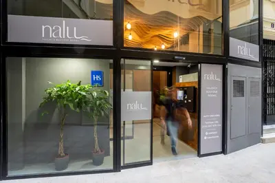 a woman walking in front of a mall window at NALU Valencia Boutique Rooms in Valencia