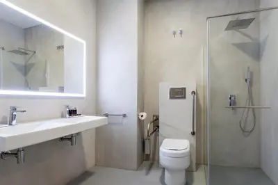 a bathroom with a toilet and a sink and a shower at NALU Valencia Boutique Rooms in Valencia
