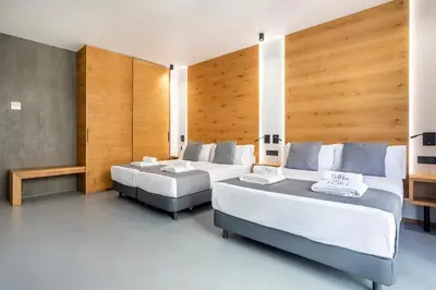 two beds in a hotel room with wooden walls at NALU Valencia Boutique Rooms in Valencia