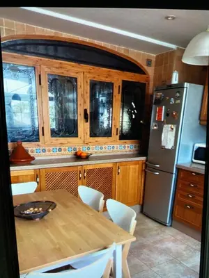 a kitchen with a wooden table and a refrigerator at Casa de Pueblo en Navarres in Navarrés
