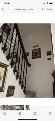 a staircase with black railings and pictures on the wall at Casa de Pueblo en Navarres in Navarrés