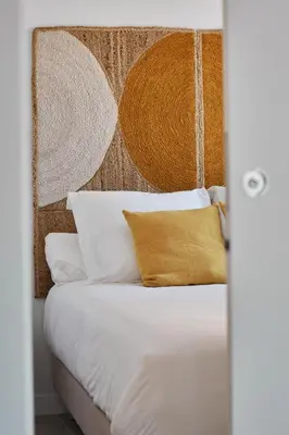 a bedroom with a bed with white sheets and yellow pillows at Slow Home Apartments in Valencia