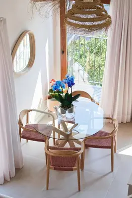 a glass table and two chairs with a vase of flowers at Slow Home Apartments in Valencia
