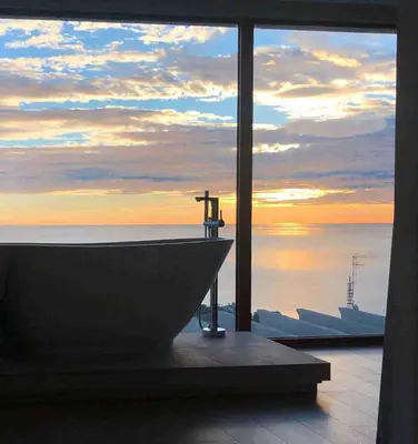 a bath tub in a room with a view of the ocean at Colina del Sol Cullera - Villa Luna in Cullera