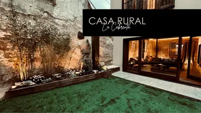 a room with a green carpet in front of a building at Casa Rural La Cabrentà in Estubeny