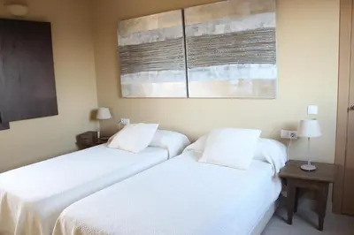 two beds in a room with white sheets at Huerto del Medico in Reig