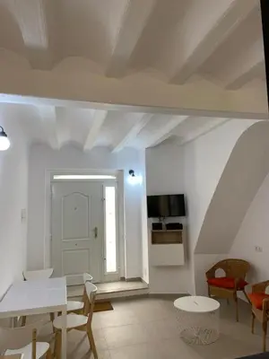 a white living room with a table and chairs at Loft Cabanyal in Valencia