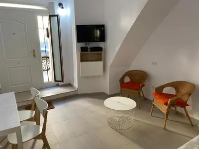 a living room with chairs and a table and a tv at Loft Cabanyal in Valencia