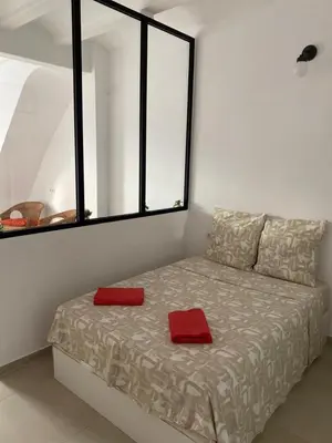a bed in a room with two red pillows on it at Loft Cabanyal in Valencia