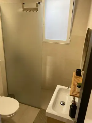 a bathroom with a sink and a toilet and a window at Loft Cabanyal in Valencia