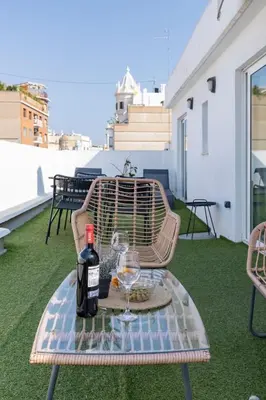 a table with a bottle of wine and two glasses at Travel Habitat - Ático Centro in Valencia