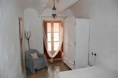 a white room with a window and a chair at CASICA TIA CARMEN in Chulilla